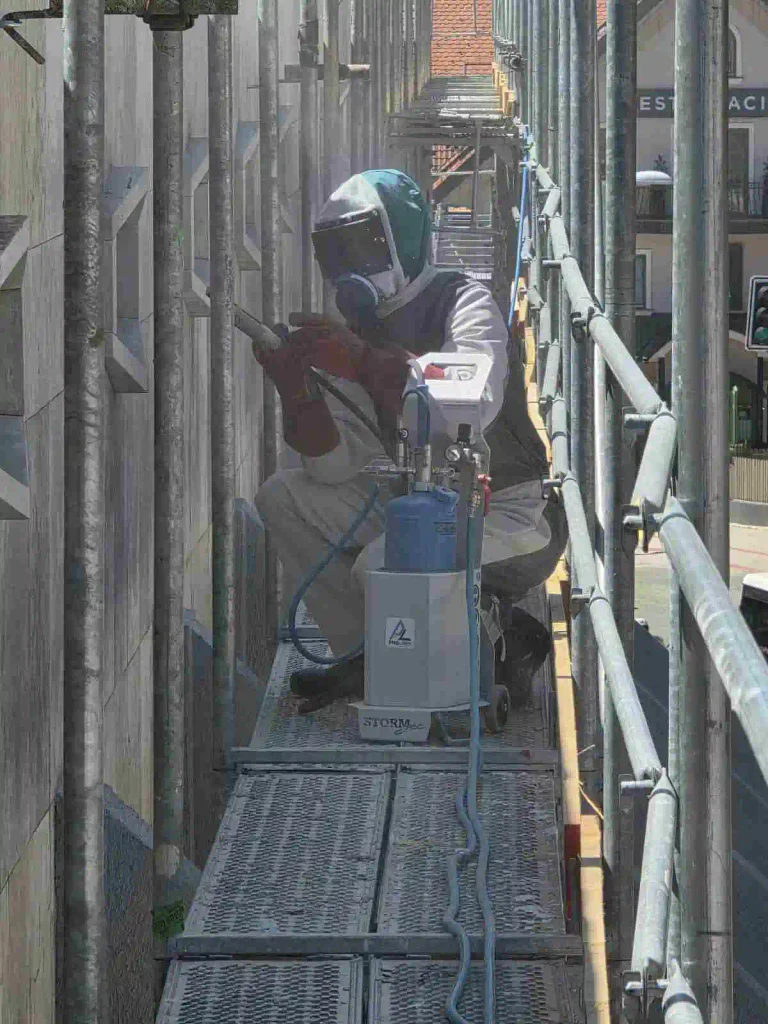 Peskanje kamnite fasade z gradbenega odra.