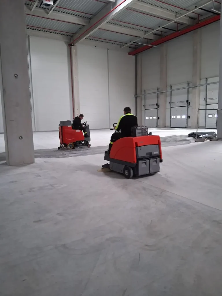 Strojno čiščenje tal v industrijski hali.